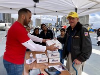 man handing package to older man
