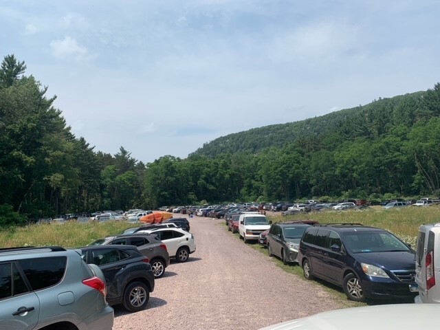 Cars lined up in the grass and on roads